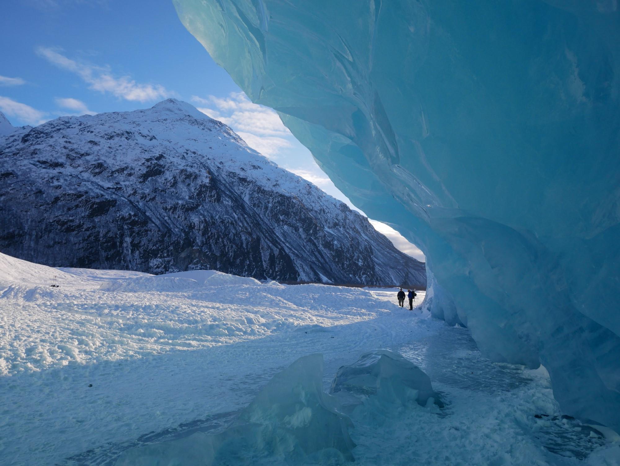 两个人站在一座雪山和一大片冰之间